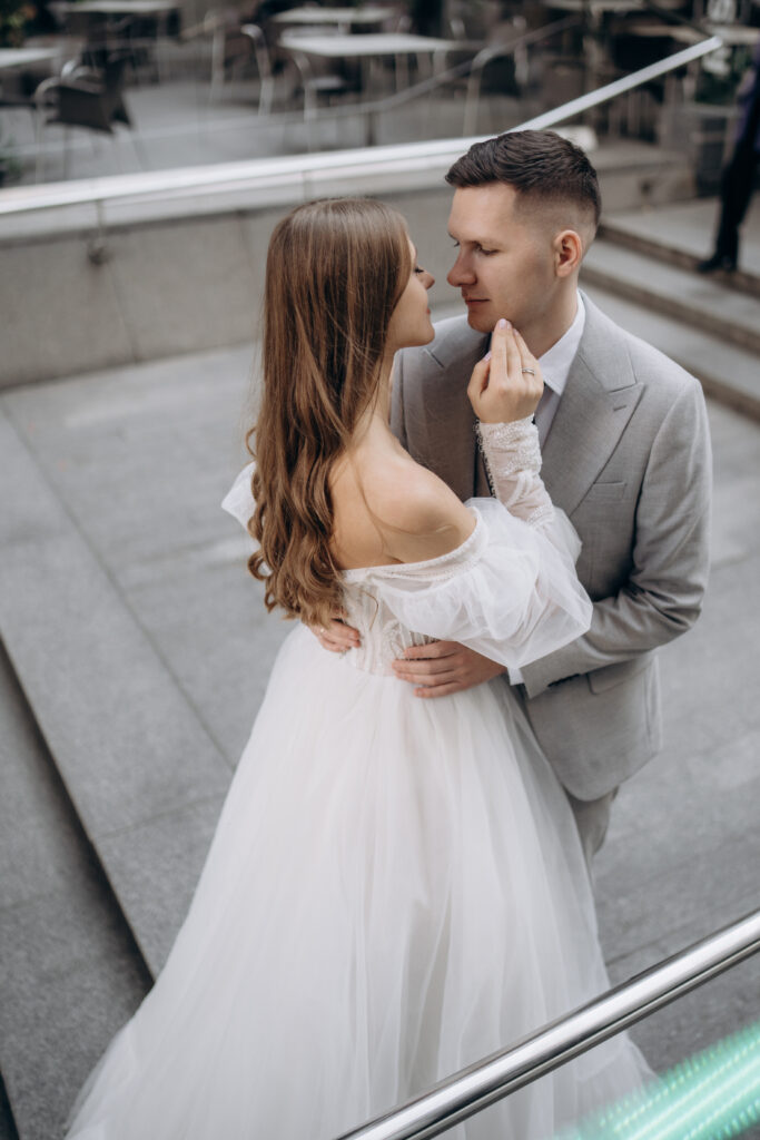 Above view of beautiful bride wearing wedding dress having photo shoot with handsome groom. Beloved couple getting married, looking at each other. Concept of wedding and marriage.
